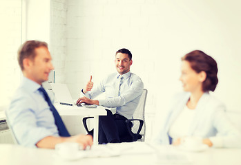 Image showing happy businessman showing thumbs up in office