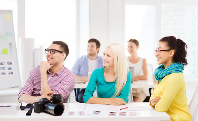 Image showing smiling team with photocamera working in office