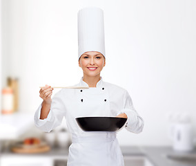 Image showing smiling female chef with pan and spoon