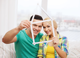 Image showing smiling couple with house from measuring tape