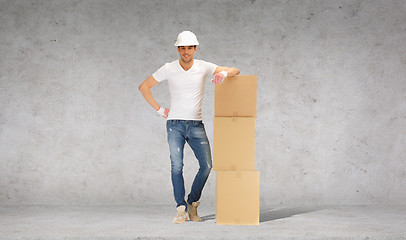 Image showing man in helmet with tower of cardboard boxes