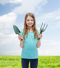 Image showing smiling little girl with rake and scoop