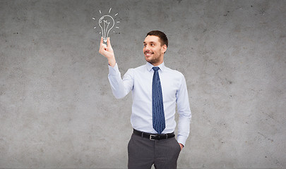 Image showing handsome businessman holding light bulb