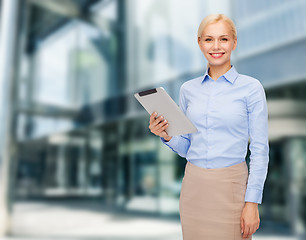 Image showing smiling woman looking at tablet pc computer