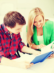 Image showing smiling students reading book at school