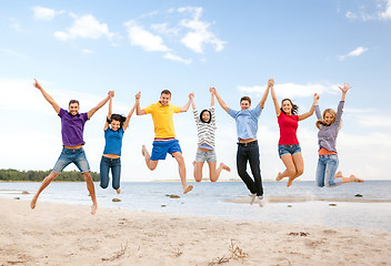 Image showing group of friends jumping on the beach