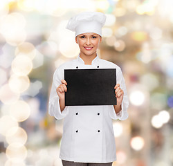Image showing smiling female chef with black blank paper