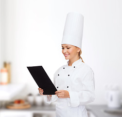 Image showing smiling female chef with black blank paper