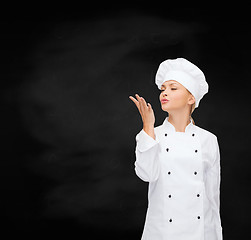 Image showing smiling female chef showing delicious sign