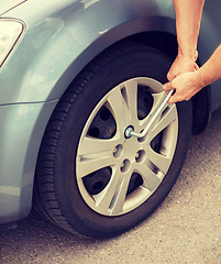 Image showing man changing tire