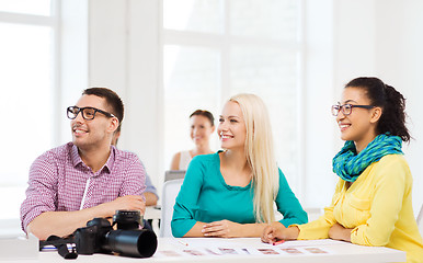 Image showing smiling team with photocamera working in office