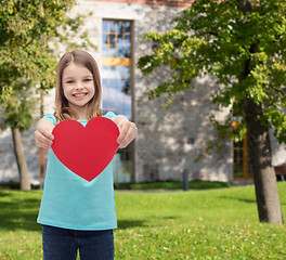 Image showing smiling little girl giving red heart