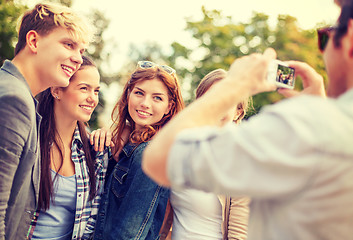 Image showing teenagers taking photo with digital camera outside