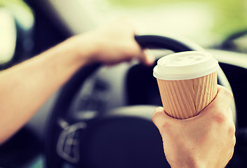 Image showing man drinking coffee while driving the car