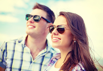 Image showing smiling teenagers in sunglasses having fun outside