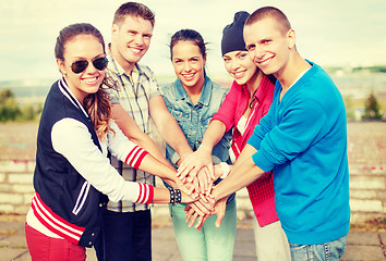 Image showing teenagers hands on top of each other outdoors