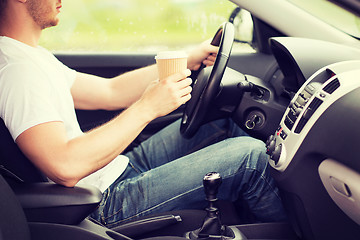 Image showing man drinking coffee while driving the car