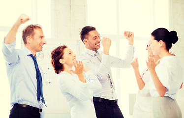 Image showing business team celebrating victory in office