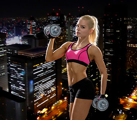 Image showing sporty woman with heavy steel dumbbells