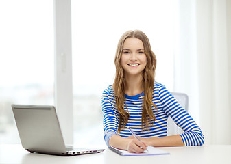 Image showing smiling teenage girl laptop computer and notebook