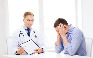 Image showing doctor with clipboard and patient in hospital