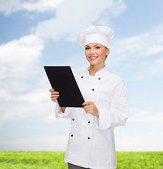 Image showing smiling female chef with black blank paper