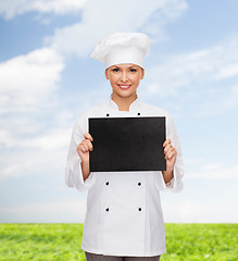 Image showing smiling female chef with black blank paper