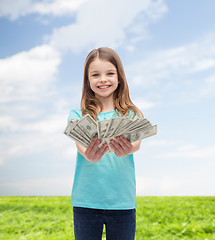 Image showing smiling little girl giving dollar cash money