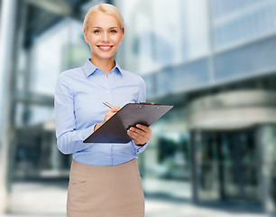 Image showing smiling woman taking notes in the city center