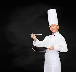 Image showing smiling female chef with pan and spoon