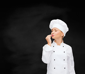 Image showing smiling female chef showing delicious sign