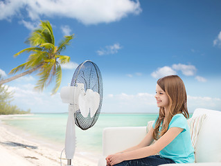 Image showing smiling little girl with big fan at home