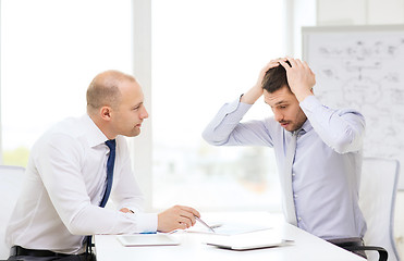 Image showing two serious businessmen with tablet pc in office