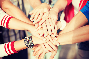 Image showing teenagers hands on top of each other outdoors