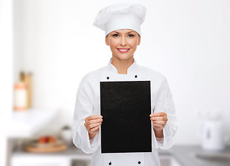 Image showing smiling female chef with black blank paper