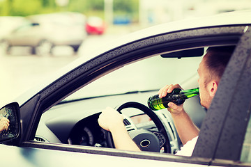 Image showing man drinking alcohol while driving the car