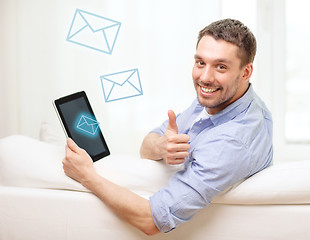 Image showing smiling man working with tablet pc at home