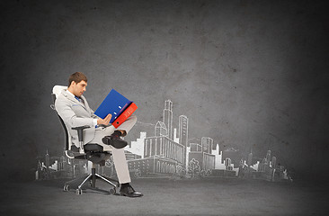 Image showing handsome businessman with folders sitting on chair