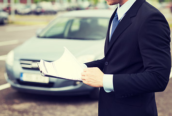 Image showing man with car documents outside