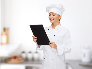 Image showing smiling female chef with black blank paper