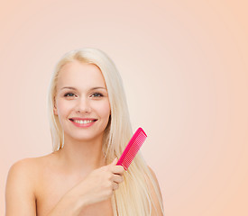 Image showing smiling woman with hair brush