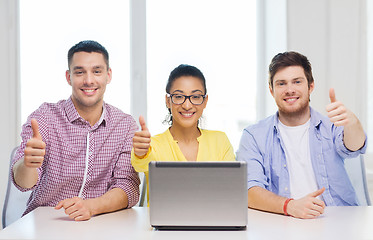 Image showing three smiling colleagues with laptop in office