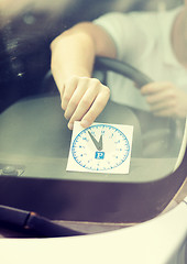 Image showing man placing parking clock on car dashboard