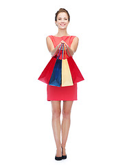 Image showing smiling elegant woman in dress with shopping bags