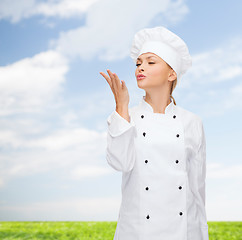 Image showing smiling female chef showing delicious sign