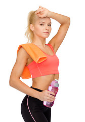 Image showing tired sporty woman with towel and water bottle