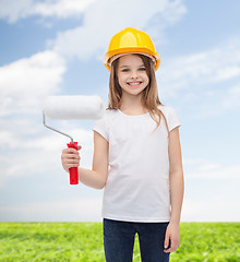 Image showing smiling little girl in helmet with paint roller