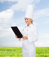 Image showing smiling female chef with black blank paper