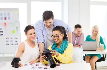 Image showing smiling team with photocamera working in office