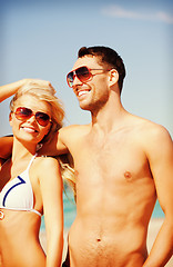 Image showing happy couple in sunglasses on the beach